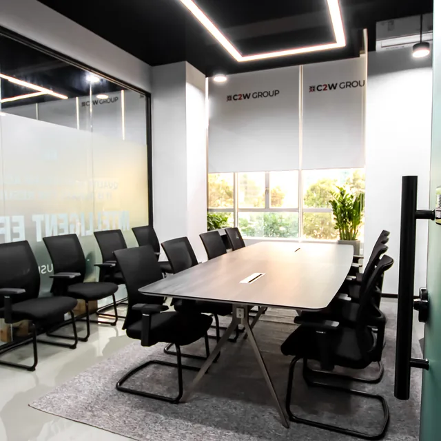A C2W Group meeting room in Zhuhai with a long conference table and branded wall