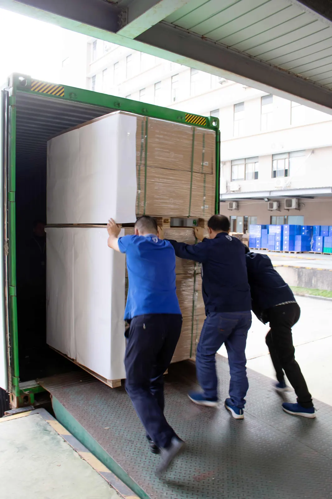 Team pushing a pallet into a shipping container at the loading dock