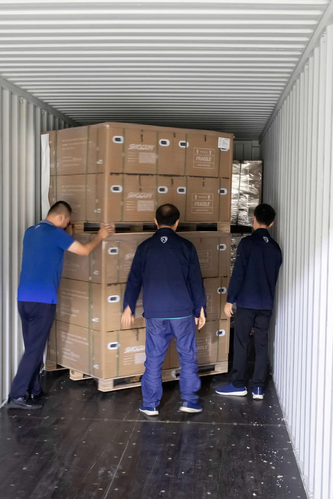 Team positioning pallets inside the container