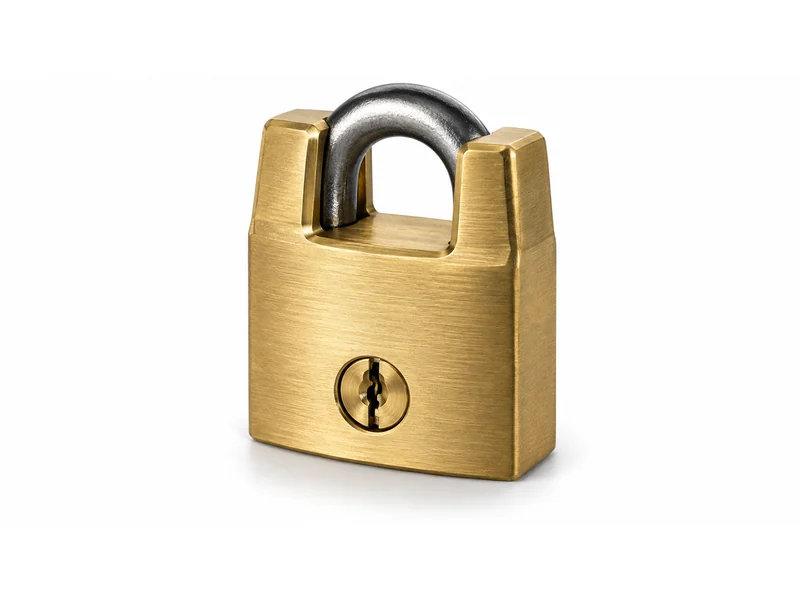 Solid brass padlock with a closed shackle shrouded by the lock body