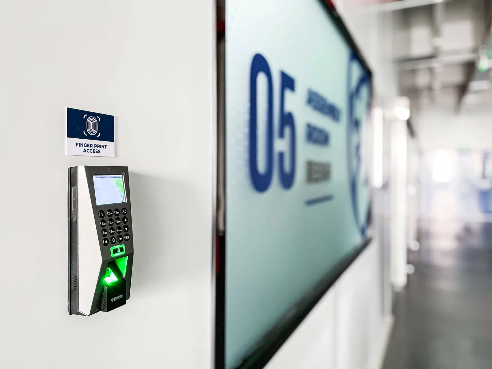 Fingerprint access control unit beside the entrance to a Shield Works assembly room