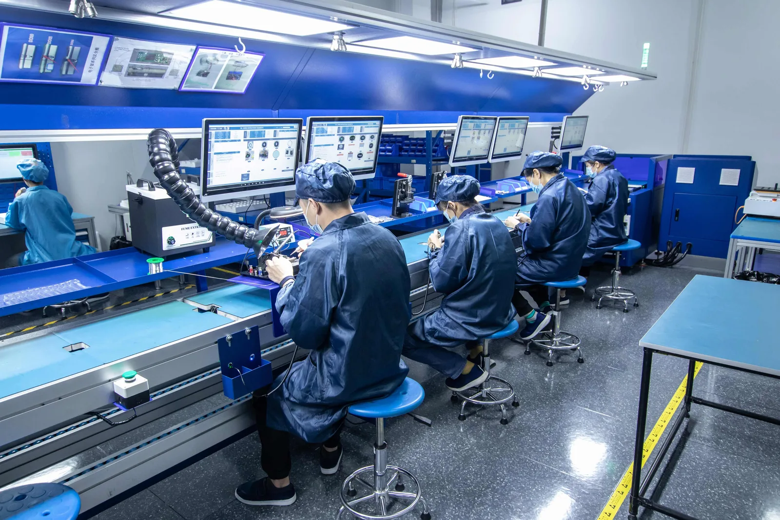 Operators assembling and testing PCBs at ESD-controlled workstations with fume extraction at Shield Works
