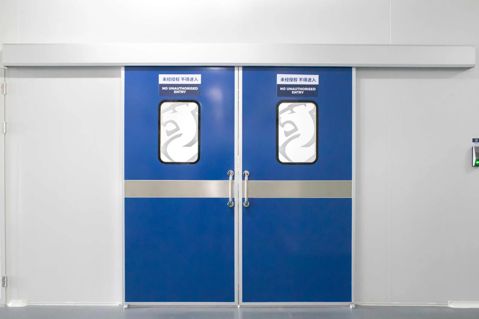 Closed blue double doors into an access-controlled assembly room