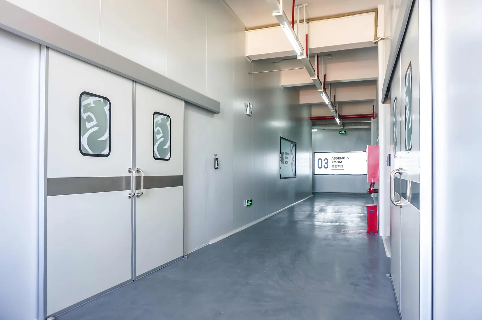 Secure production corridor with sliding doors marked by the Shield Works lion crest