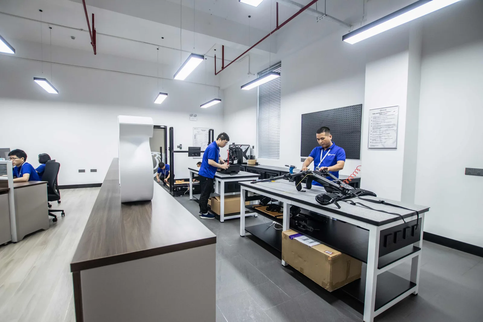 Engineers at test benches in the Shield Works DFX lab, working on prototype assemblies