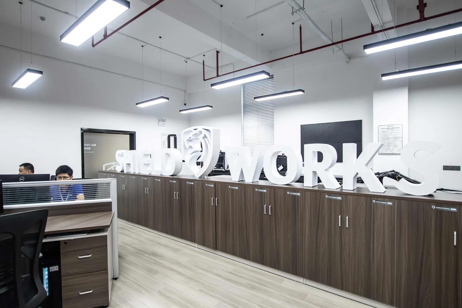 The DFX engineering office, with desks beneath large Shield Works lettering
