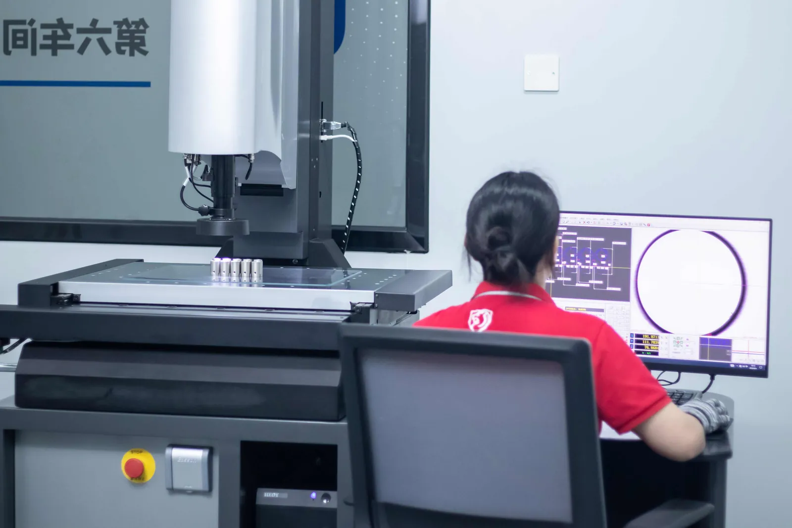 An inspector running an optical measurement machine, with the part profile on screen