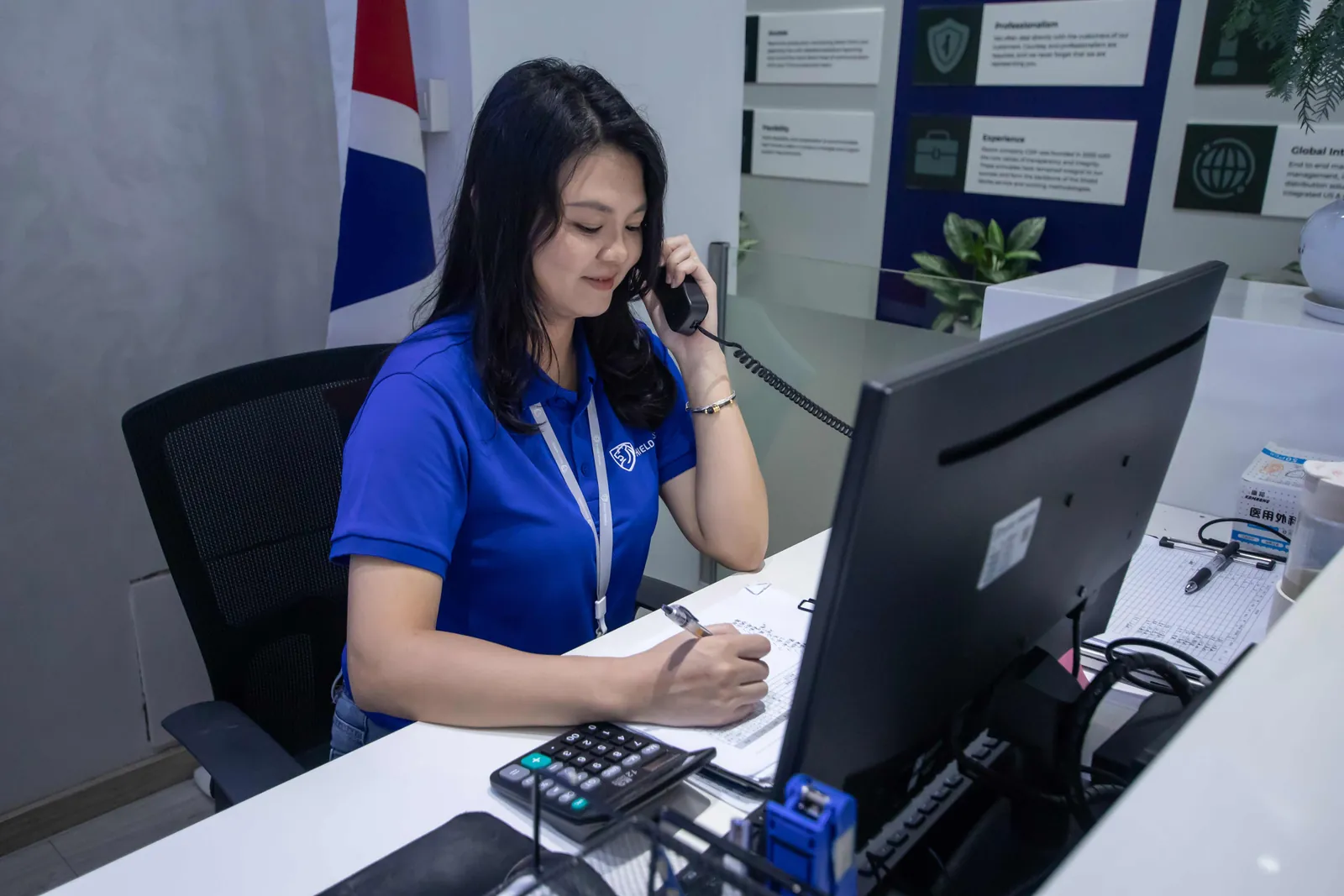 A Shield Works team member taking a call at her desk