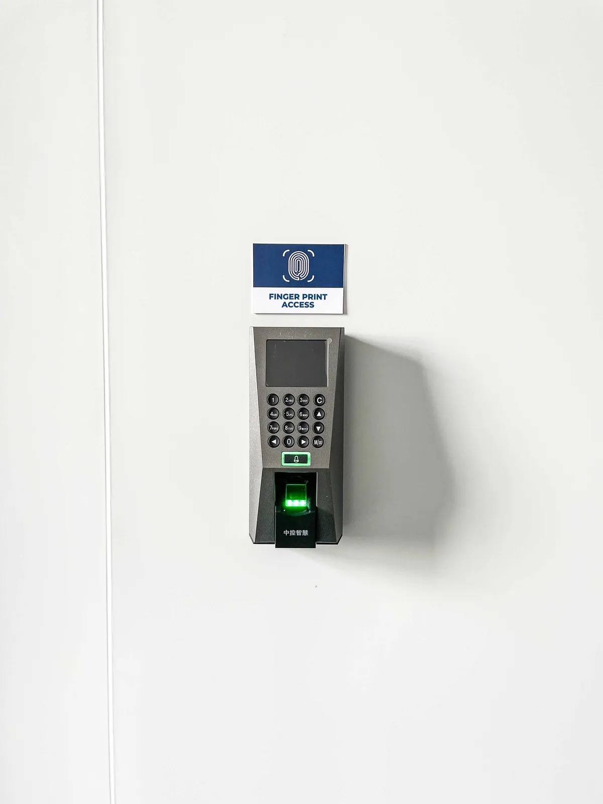 Wall-mounted fingerprint-access reader and Finger Print Access sign at the entry to a secure assembly room at Shield Works