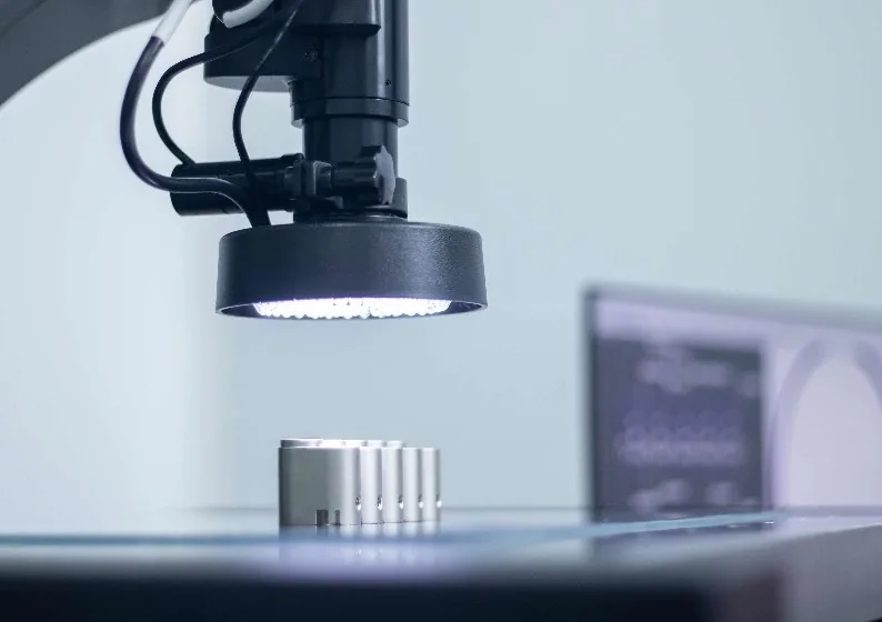 Vision measurement lens and ring light over machined parts