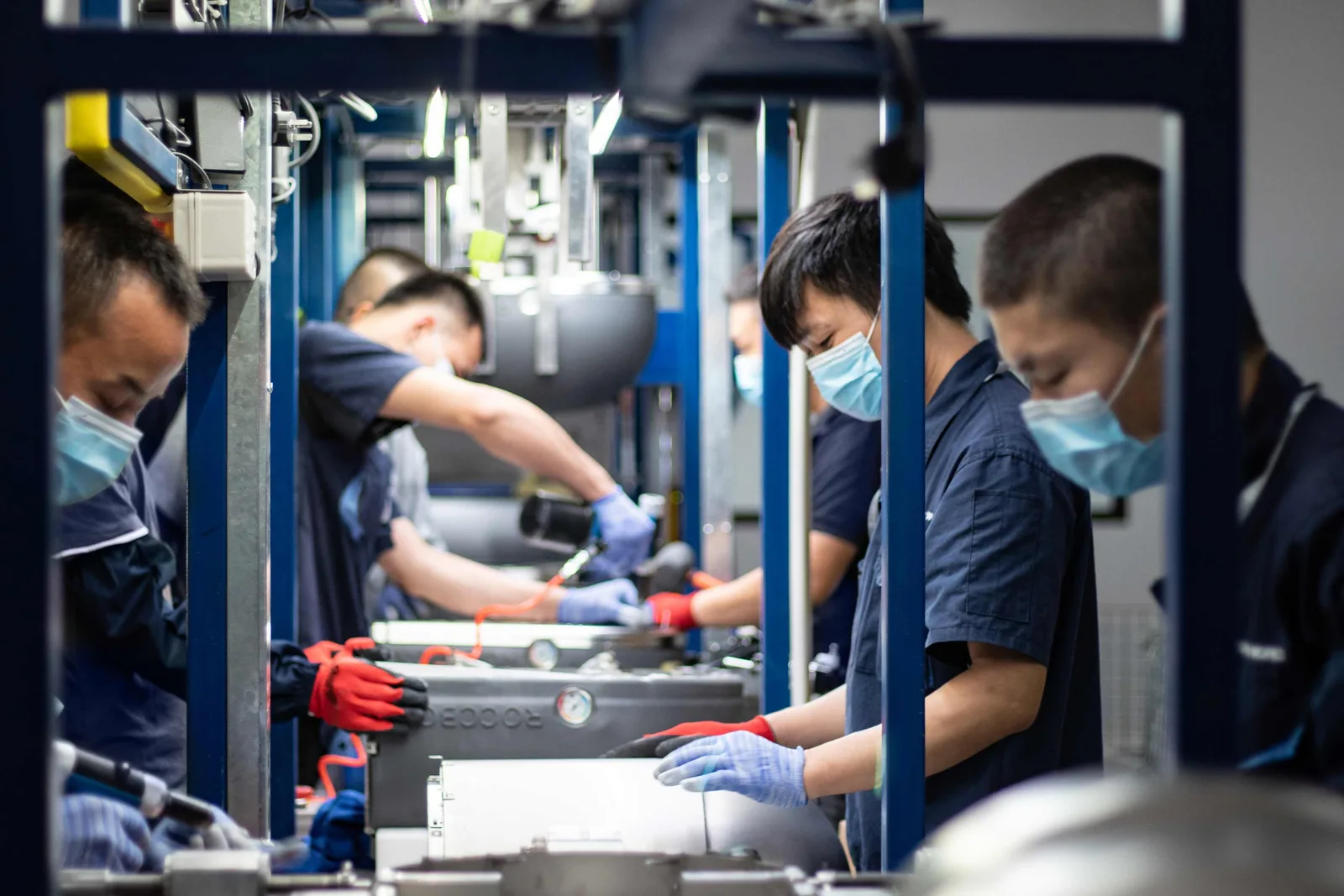 Operators in Shield Works uniforms working an assembly line in one of the Zhuhai assembly rooms