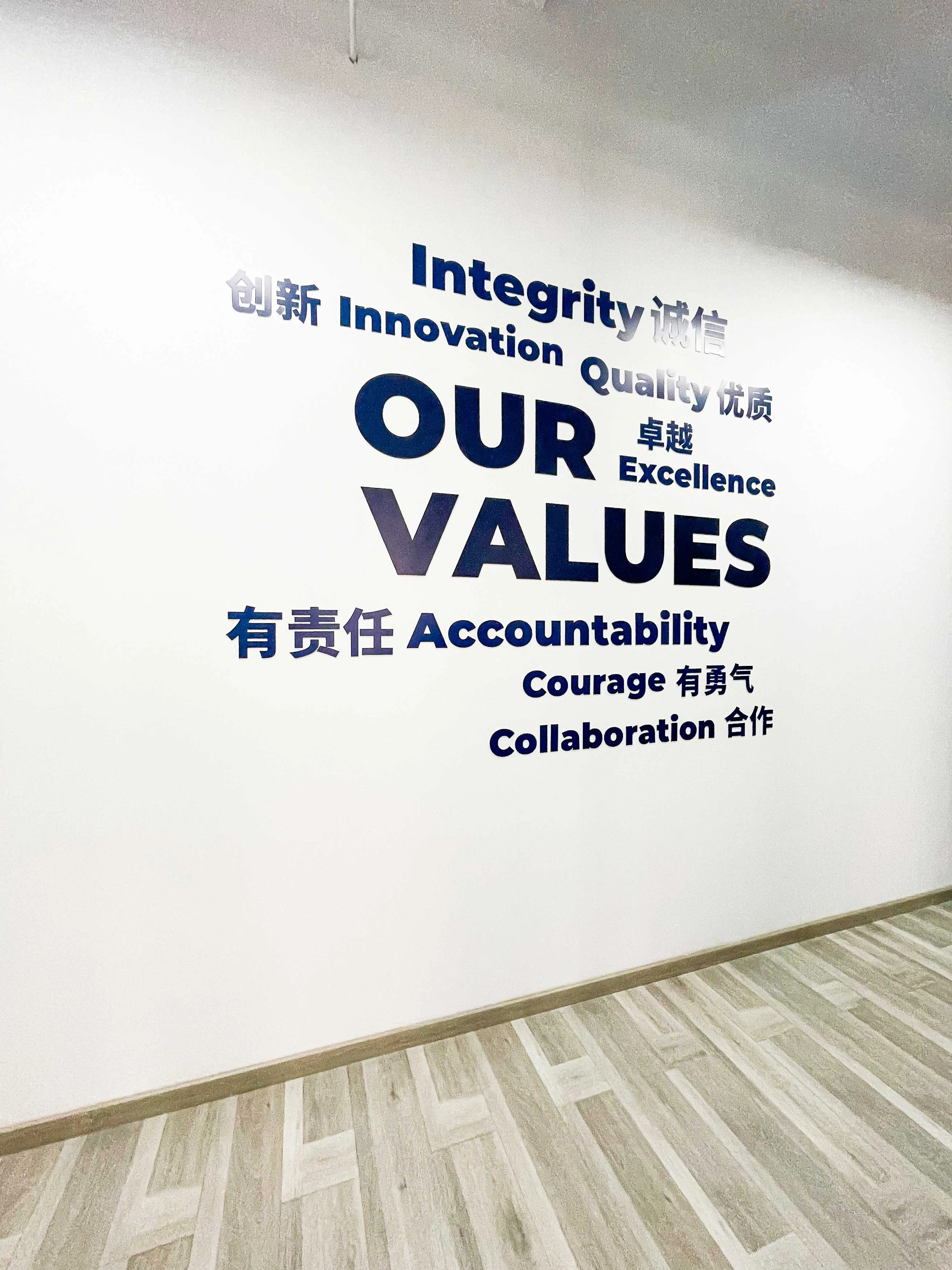 The Our Values wall at Shield Works' Zhuhai facility, displaying Integrity, Innovation, Quality, Excellence, Accountability, Courage, and Collaboration in English and Chinese.