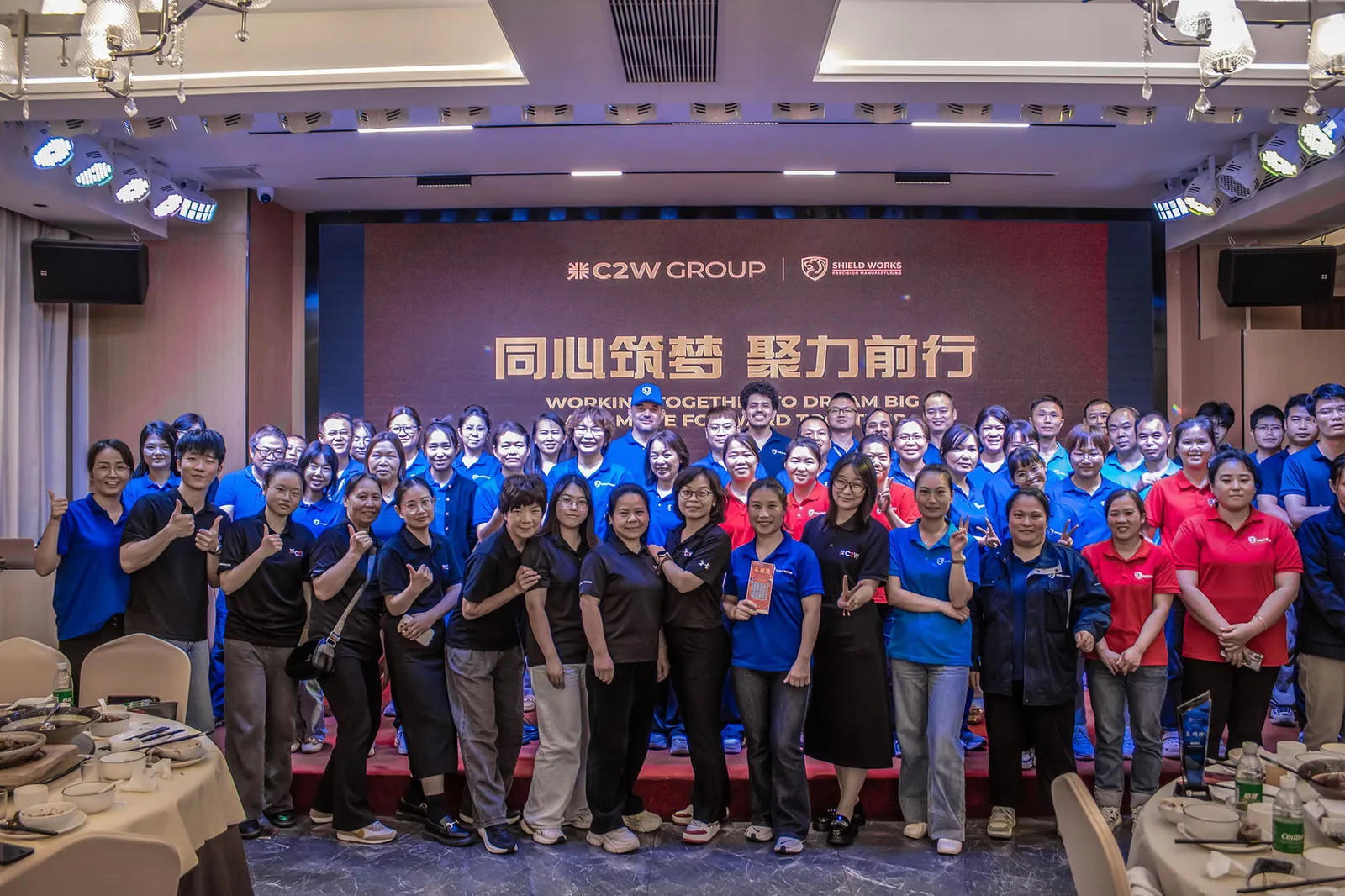 Shield Works and C2W Group team gathered at a company event in Zhuhai under a banner reading "Working Together to Dream Big"