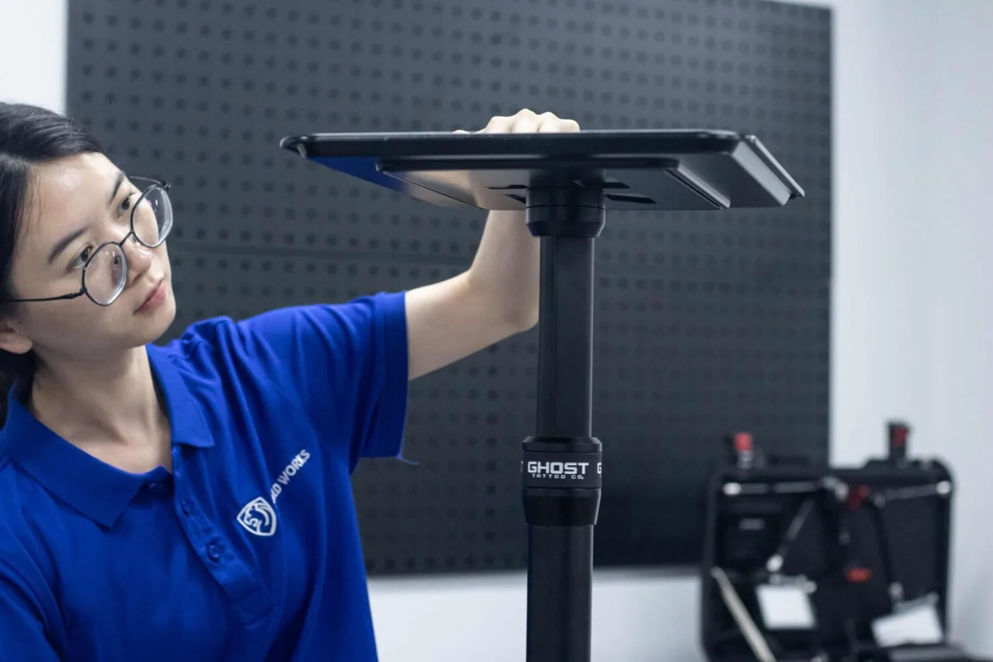 Shield Works engineer inspecting an assembled product on a stand against a perforated tool wall